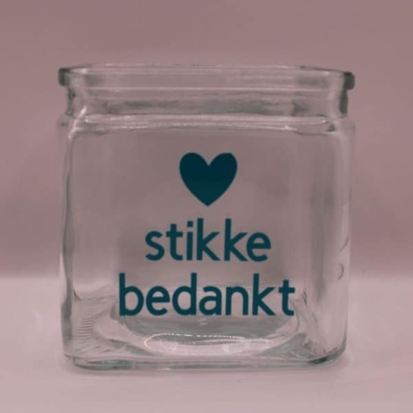 Bestel nu deze leuke glazen theelichthouder die je kunt personaliseren naar wens. op deze glazen theelichthouder ( accubak) heeft een tekst hartstikke bedankt waarvan hart een sticker in hartvorm is, verkrijgbaar in verschillende kleuren