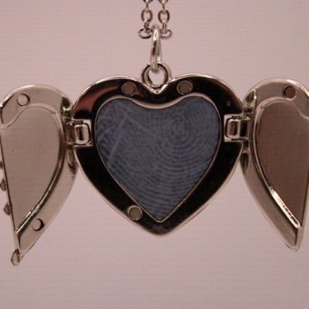 ketting met hartvormige hanger die je open en dicht kunt doen, in het hartje is ruimte voor een vingerafdruk, de ketting en het hartje zijn zilverkleurig