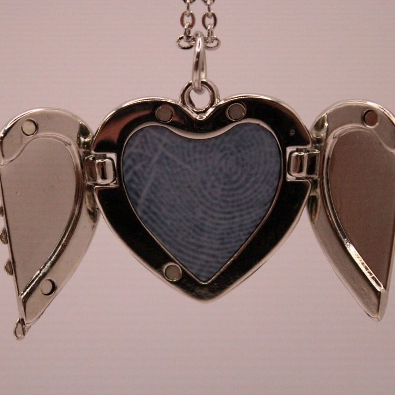 ketting met hartvormige hanger die je open en dicht kunt doen, in het hartje is ruimte voor een vingerafdruk, de ketting en het hartje zijn zilverkleurig