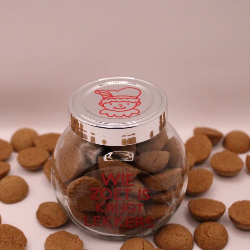 glazen potje gevuld met pepernoten en een rood pietje op de deksel, op het potje staat de tekst; wie zoet is krijgt lekkers in het rood